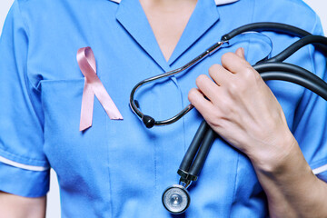 Close-up female nurse with with stethoscope, pink ribbon