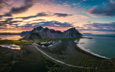 Vestrahorn mountain and dramatic sky over black sand beach in the dusk at Stokksnes peninsula,...
