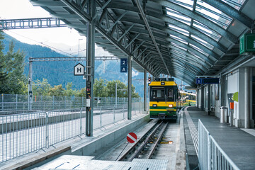 Train is coming on railway to station in Switzerland