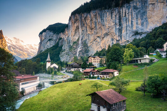 View of Lauterbrunnen valley with rustic village, famous church and Staubbach falls during end of summer at Switzerland