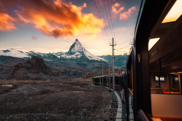 View from train with sunrise over Matterhorn mountain during ride up to Gornergrat station in...