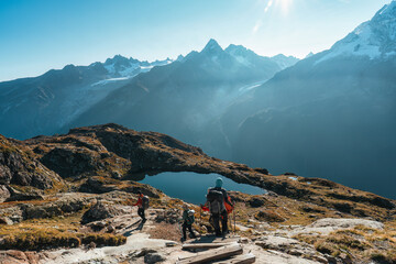 Landscape of group of hiker climbing on Lac des Cheserys with Mont Blanc massif in autumn on sunny day at France