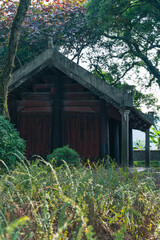 Wooden garden temple with lush green vegitation surrounding at a Buddhist temple in Vietnam, in Asia