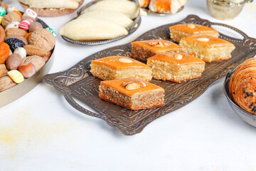 Traditional Azerbaijan holiday Novruz background with green semeni,traditional azerbaijan sweets,shekerbura,qogal,paxlava,mutaki and different nuts and sweets,top view,space for copy