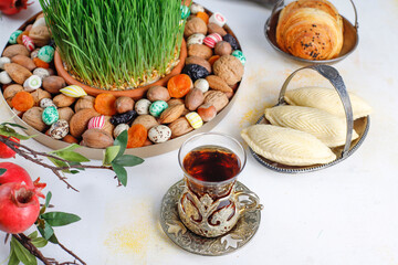 Traditional Azerbaijan holiday Novruz background with green semeni,traditional azerbaijan sweets,shekerbura,qogal,paxlava,mutaki and different nuts and sweets,top view,space for copy