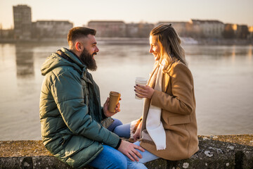 Happy couple enjoy drinking coffee and spending time together outdoor.	