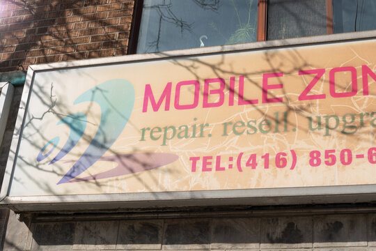 vintage light box sign of Mobile Zone Plus, a cell phone store, located at 1897 Eglinton Avenue West in Toronto, Canada