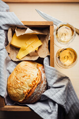 White wine, bread, cheese on the table.