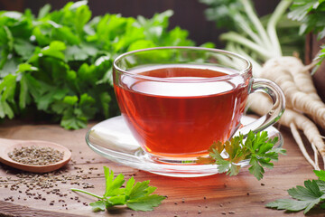 Parsley tea with fresh seeds, leaves, roots nearby on rustic wooden table, copy space, natural remedy for kidney, heart, menstrual, blood desease, healthy organic food concept