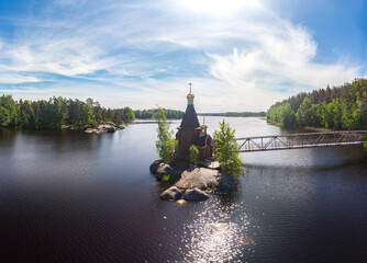 Aerial top view to wooden Church of St. Apostle Andrew First-Called on Vuoksa River with bridge....
