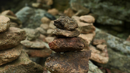 Fototapeta na wymiar Close-up of stacked towers of stones. Clip. Mountain stones were stacked in turrets. Stacked turrets of rocks on background of rocks