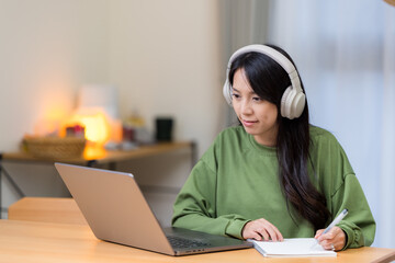 Woman study on laptop computer with her headphone