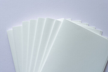 blank paper signatures stack with staggered edges on textured paper