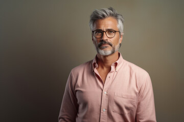 Fototapeta premium Portrait of a senior man with white hair, wearing glasses and a pink shirt