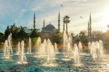 The Blue Mosque or Sultanahmet Mosque with fountains against the sunset. Istanbul, Turkey.