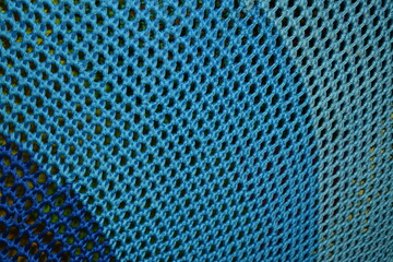 Shades of blue on woven mesh. Background