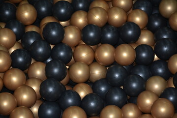 Golden black balls in a dry pool close up