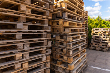 Piles of stacked natural wooden shipping pallets.
