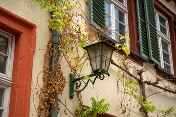 old, green street lamp on a house wall