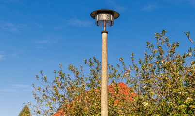 Old GDR street lamp in front of a blue sky