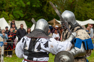 Two men in medieval armor fighting during a buhurt demonstration