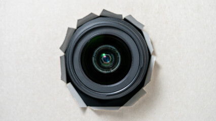 Object photo through torn piece of paper, white torn paper cardboard inside a hole lens, camera,...