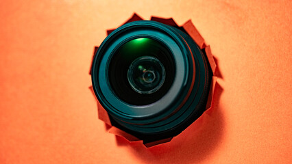 Object photo through torn piece of paper, red torn paper cardboard inside a hole lens, camera,...