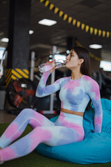 Fitness woman drinking water at the gym - 748217022