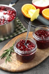 Fresh cranberry sauce in glass jars served on gray table