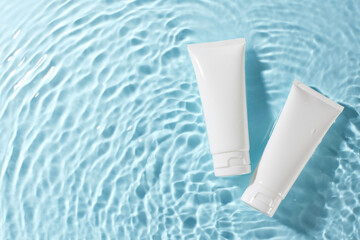 Natural beauty: embracing organic cosmetics. Top view shot of two white skincare tubes floating on...