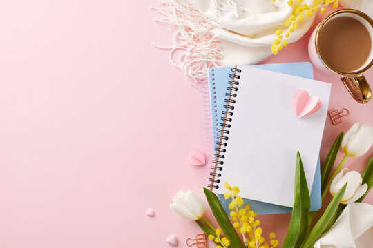 Whispers of Women's day: A symphony of spring and creativity. Top view photo of tulips, notebook, scarf and cup of coffee on a pink surface, providing generous space for heartfelt messages