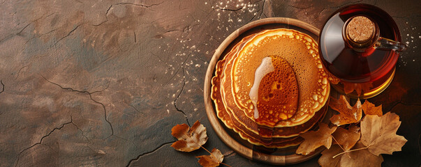 A bottle of maple syrup and a pancake on a brown background. Canadian specialty with sweet and...