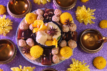 Obraz na płótnie Canvas Diwali celebration. Flat lay composition with diya lamps and tasty Indian sweets on shiny violet table