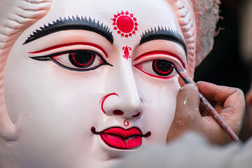 Painting the eyes of hindu goddess Saraswati idol from kumartuli	