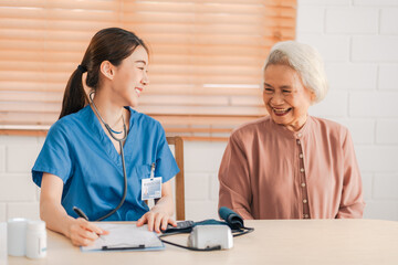 Medical health insurance service, Asian caregiver doctor examine older patient use blood pressure gauge. Young woman therapist nurse nursing home taking care to senior elderly woman - Powered by Adobe