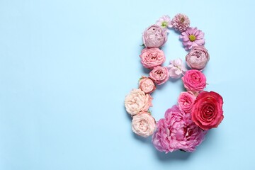 8 March greeting card design made with beautiful flowers on light blue background, top view. Space for text