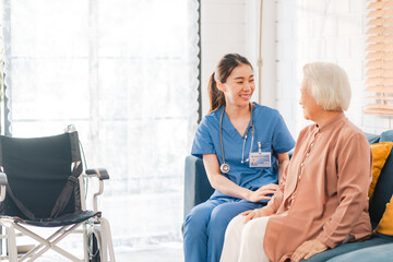 Elderly senior woman, asian woman doctor nursing home to helping take care to retirement patient who sitting on wheelchair, caregiver nurse support to medical health care insurance at home or hospital © chokniti