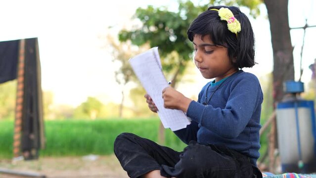 Asian girl of student dress doing homework in countryside.Child education and countryside life concept, Rural india.
