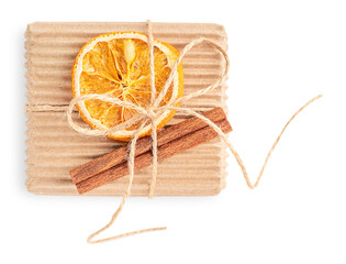 Top view of craft carton eco friendly gift box tied up with string decorated with dried orange citrus fruit slice and cinnamon stick isolated on white background used as zero waste holiday present