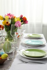 Easter celebration. Festive table setting with beautiful flowers and painted eggs