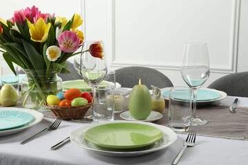 Easter celebration. Festive table setting with beautiful flowers and painted eggs