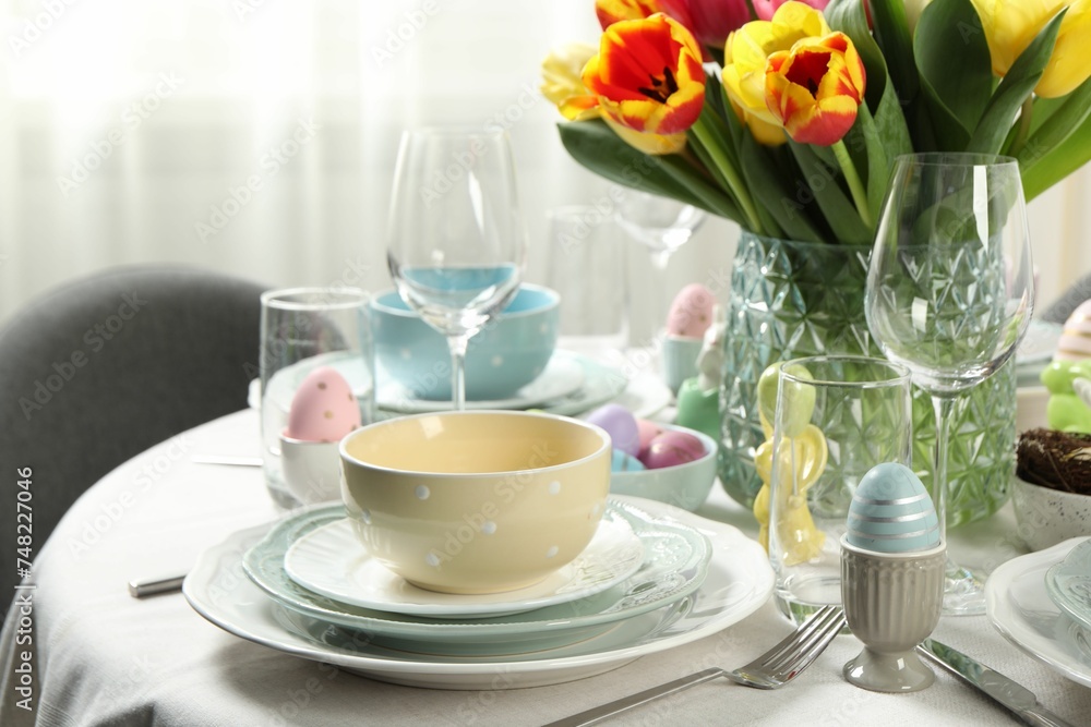 Wall mural Easter celebration. Festive table setting with beautiful flowers and painted eggs