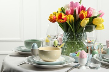 Easter celebration. Festive table setting with beautiful flowers and painted eggs