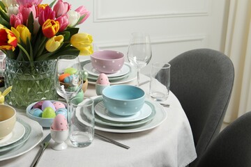 Easter celebration. Festive table setting with beautiful flowers and painted eggs