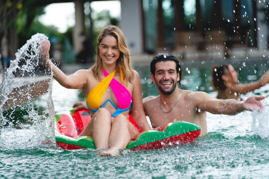 friendship lifestyle to happy fun in summer vacation holiday, young caucasian woman and man friend group in swimming pool water party, female person in swimwear bikini, outdoor enjoyment smiling girl