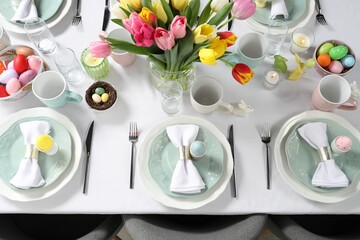 Festive Easter table setting with beautiful flowers, above view