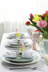 Easter celebration. Festive table setting with beautiful flowers and painted eggs