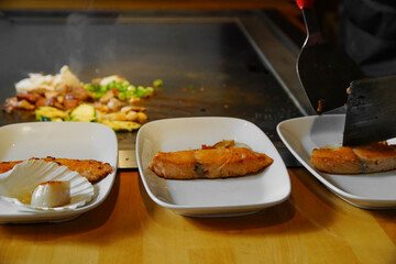 chef's hands with spatula over teppanyaki. Teppan show