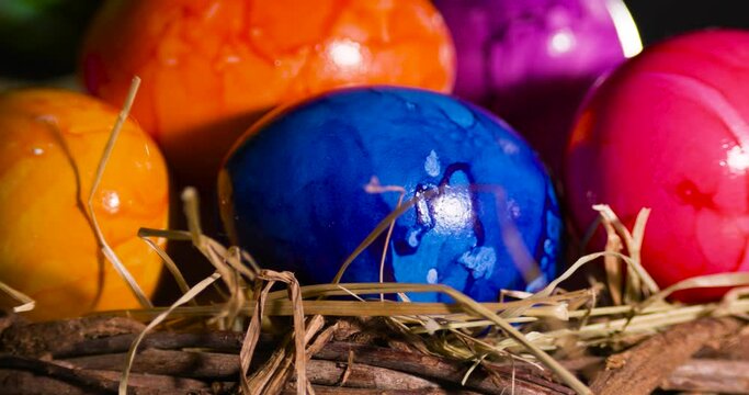 Painted colourful eggs in a hay basket.
