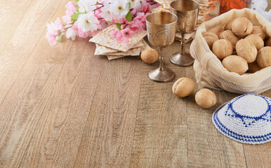 Fototapeta na wymiar Passover celebration concept. Matzah, red kosher and walnut on wooden vintage table table in front of spring blossom tree garden and flowers landscape with sun rays with copy space. Mock up.